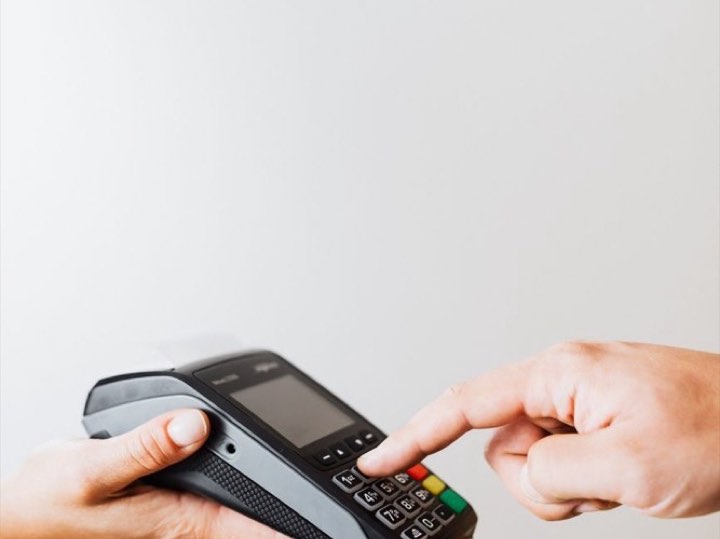 Hand using a card payment terminal